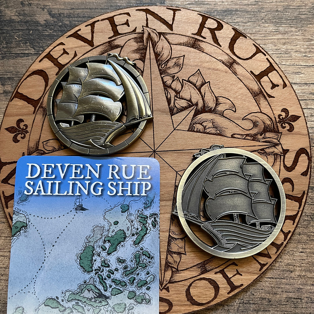 A pair of sturdy antique bronze finished coins with cutout ship illustrations by Deven Rue, one on each side to show the texture of the relief on each side.