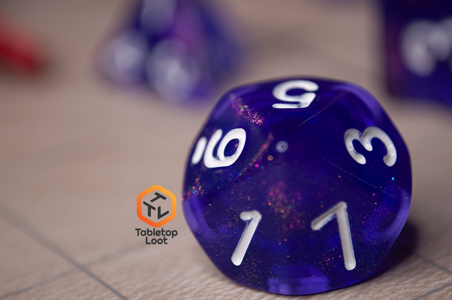 A close up of the D10 from the Diamond Purple 7 piece dice set from Tabletop Loot with purple dice filled with micro glitter and white numbering.