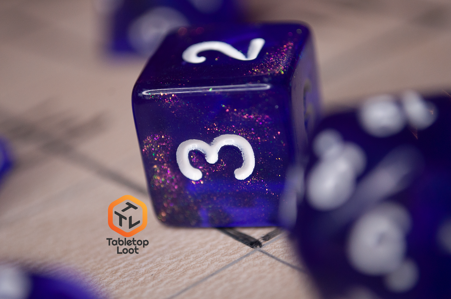 A close up of the D6 from the Diamond Purple 7 piece dice set from Tabletop Loot with purple dice filled with micro glitter and white numbering.
