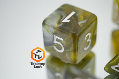 A close up of the D6 from the Disintegrate 7 piece dice set from Tabletop Loot with swirls of silver and gold and white numbering.