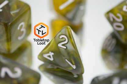 A close up of the D4 from the Disintegrate 7 piece dice set from Tabletop Loot with swirls of silver and gold and white numbering.