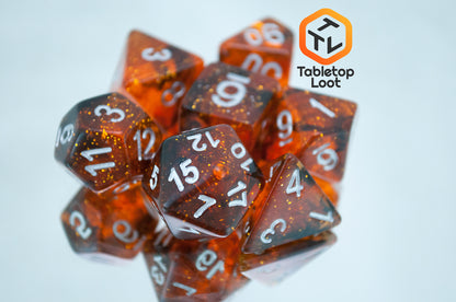 The Dissonant Whispers 7 piece dice set from Tabletop Loot with swirls of black in sparkling amber color, inked in silver.