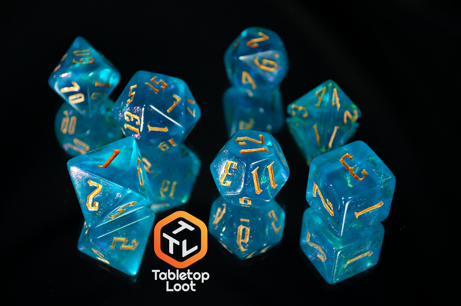 The Draconic Seas 7 piece dice set from Tabletop Loot with shimmering translucent blue resin and gold numbering.