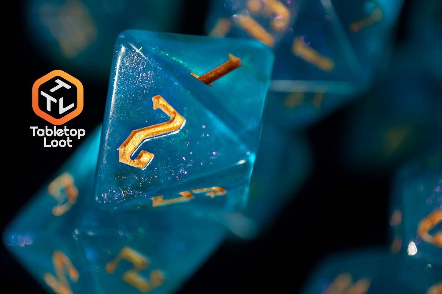 A close up of the D8 from the Draconic Seas 7 piece dice set from Tabletop Loot with shimmering translucent blue resin and gold numbering.
