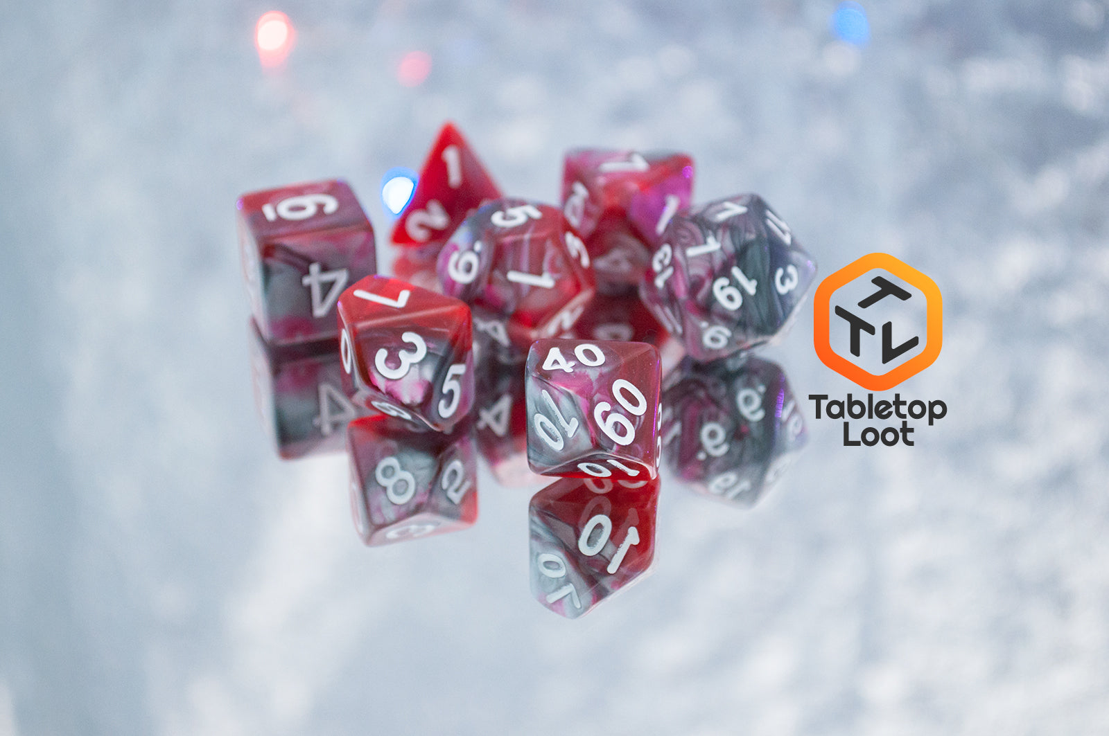 The Dragon's Blood 7 piece dice set from Tabletop Loot with swirled red and grey resin and white numbering.