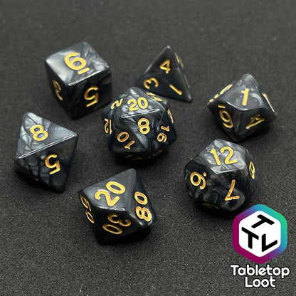 The Dreadnaught 7 piece dice set from Tabletop Loot with swirls of pearlescent black and gold numbering.