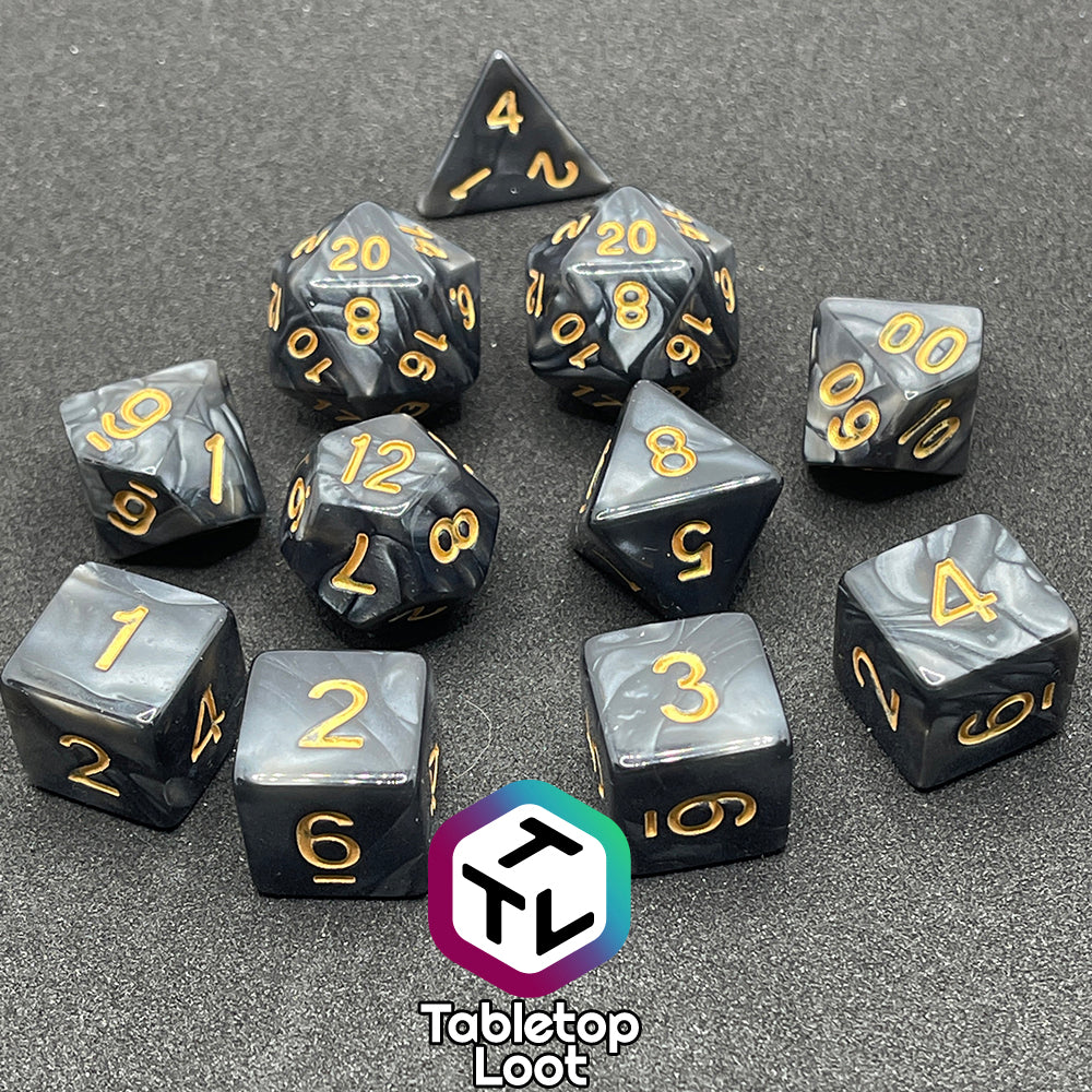 The Dreadnaught 11 piece dice set from Tabletop Loot with swirls of pearlescent black and golden numbering.