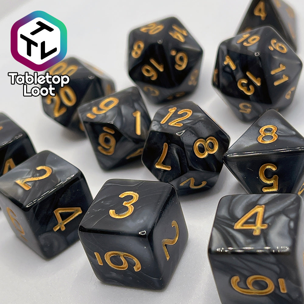 A close up of the Dreadnaught 11 piece dice set from Tabletop Loot with swirls of pearlescent black and golden numbering.