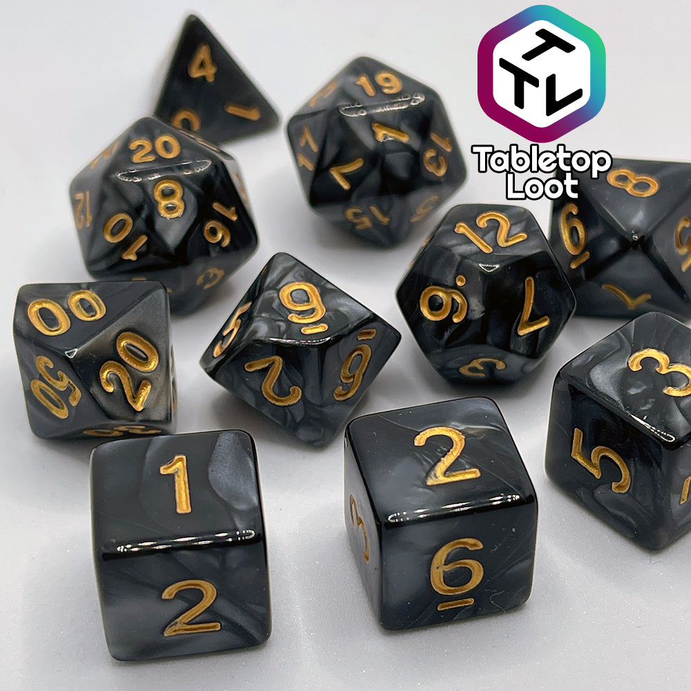 The Dreadnaught 11 piece dice set from Tabletop Loot with swirls of pearlescent black and golden numbering.
