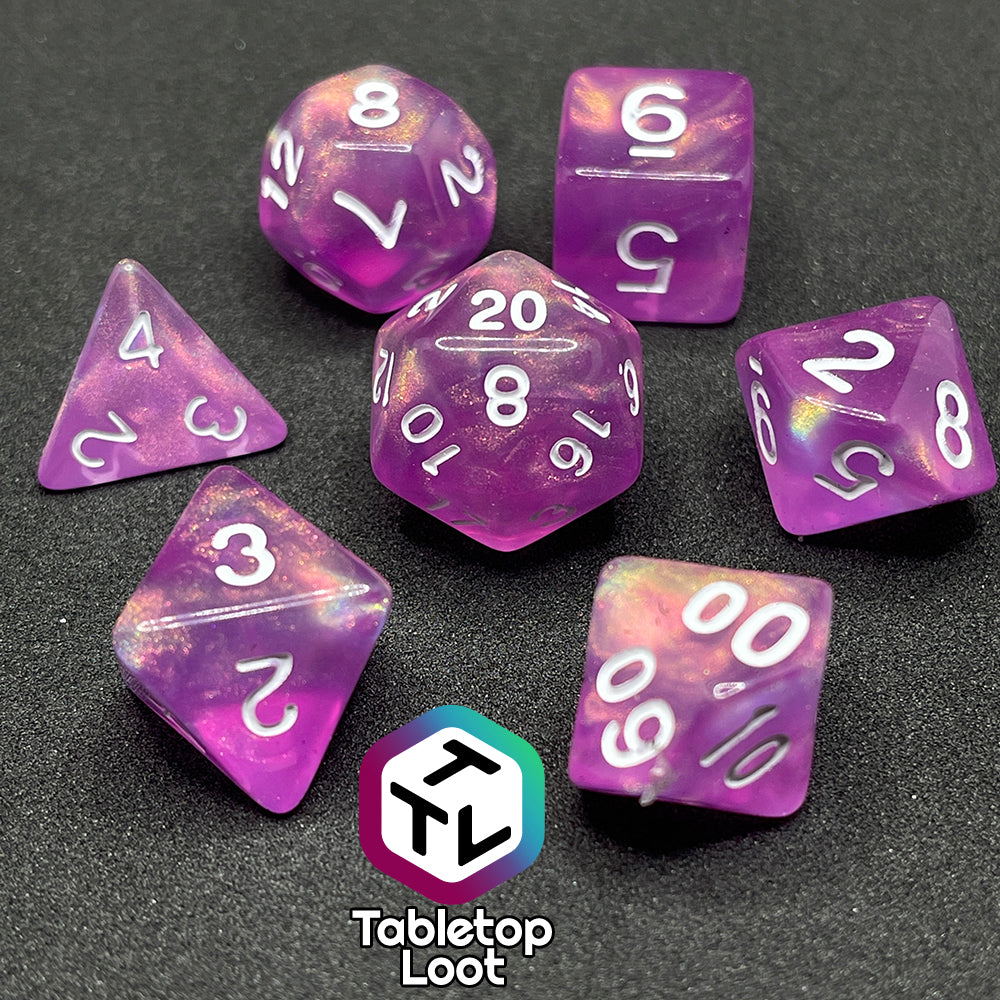 The Dreamscapes 7 piece dice set from Tabletop Loot; pink with iridescent glitter and white numbering.