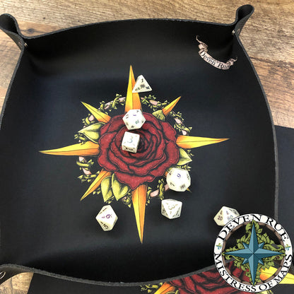 The Druid Compass Rose snappy dice tray with dice inside.
