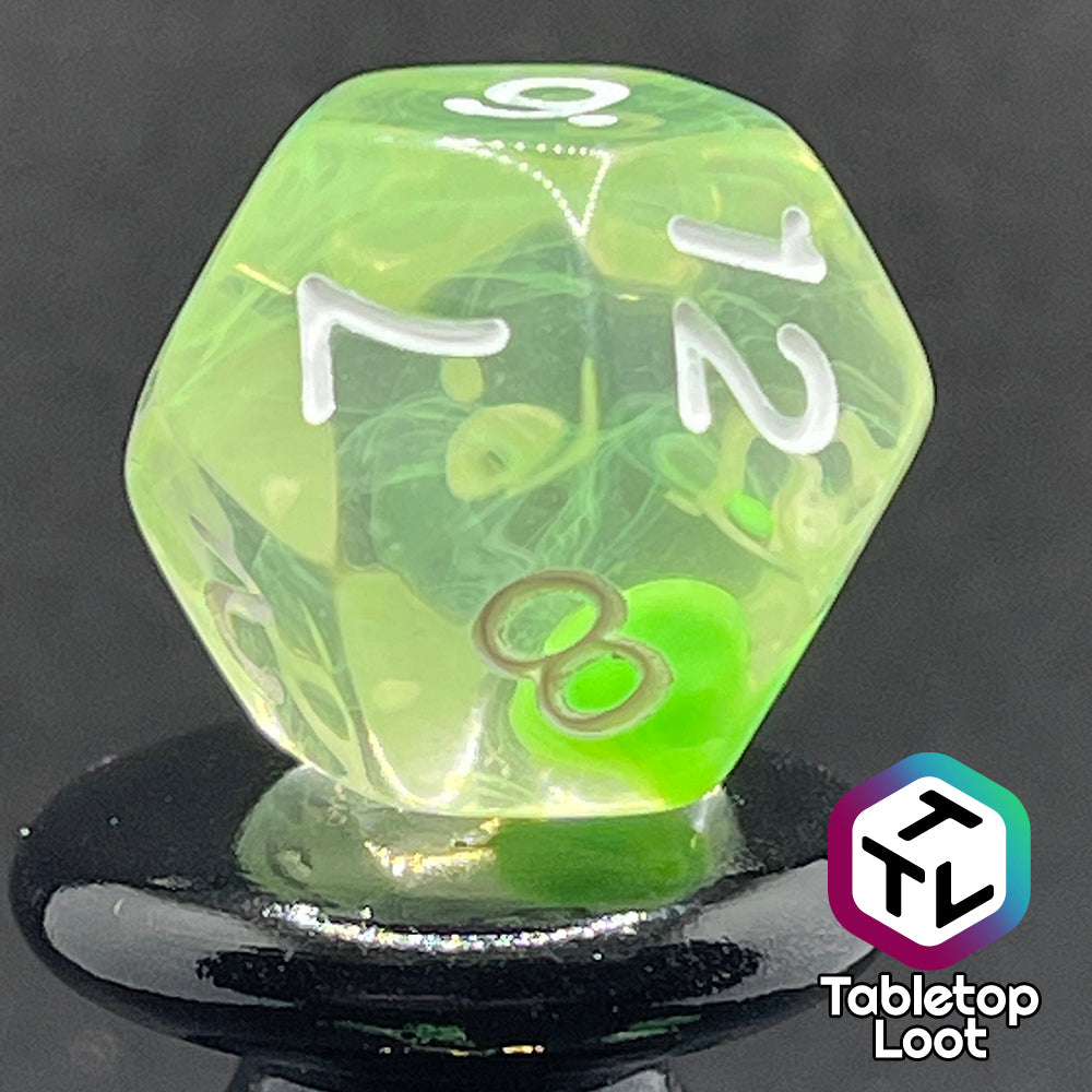 A close up of the D12 from the Ectoplasm 7 piece dice set from Tabletop Loot with swirls of lime green in clear resin and white numbering.