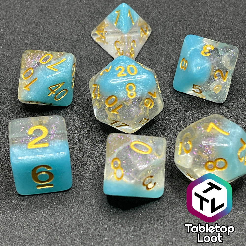 The Elsa 7 piece dice set from Tabletop Loot with a layer of sky blue under glittery clear resin and golden numbering.