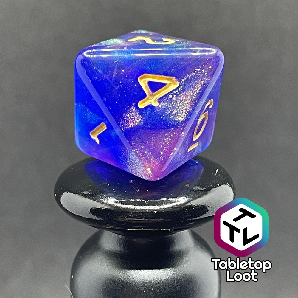 A close up of the D8 from the Elvish Magic 7 piece dice set from Tabletop Loot with shimmering swirls of red, pink, and purple in blue with gold numbering.