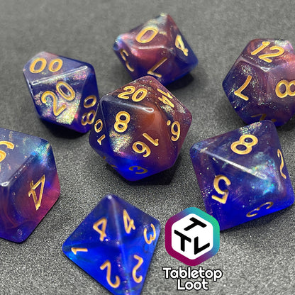 The Elvish Magic 7 piece dice set from Tabletop Loot with shimmering swirls of red, pink, and purple in blue with gold numbering.