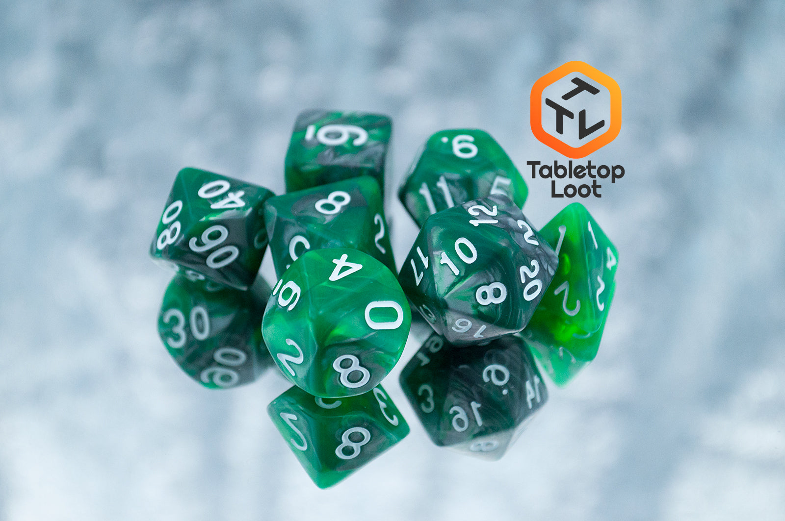 The Emerald Ore 7 piece dice set from Tabletop Loot with swirls of green and silver resin and white numbering.