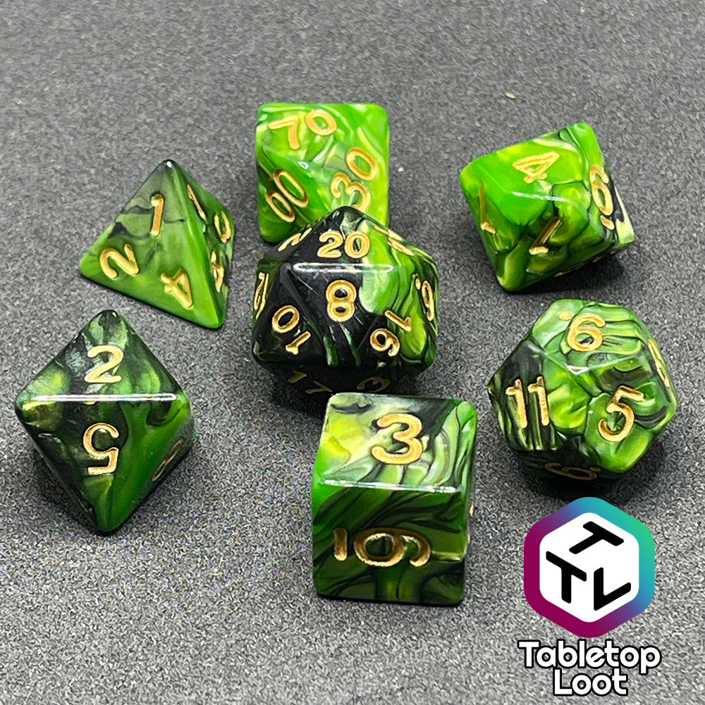 The Entangle 7 piece dice set from Tabletop Loot with swirls of pearlescent green and black and golden numbering.