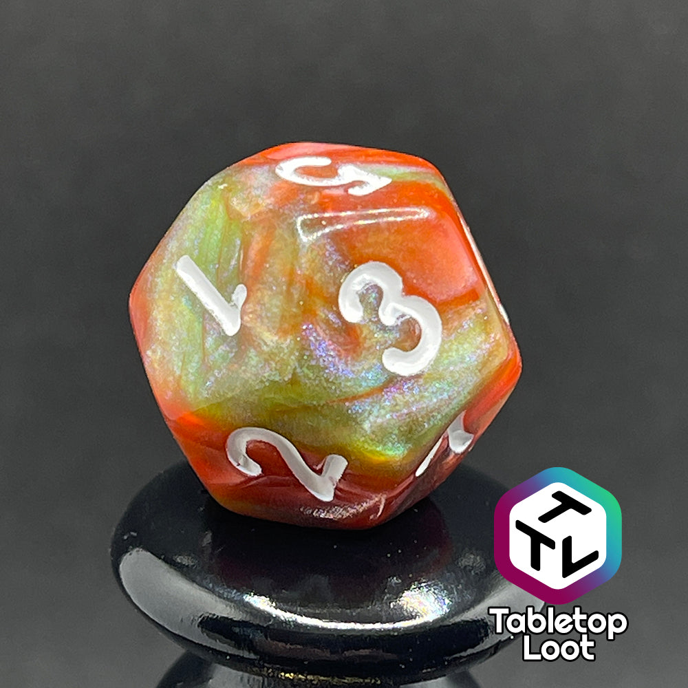 A close up of the D12 from the Ether Stone 7 piece dice set from Tabletop Loot with glittering and pearlescent swirls of red, green, blue, and golden brown with white numbering.
