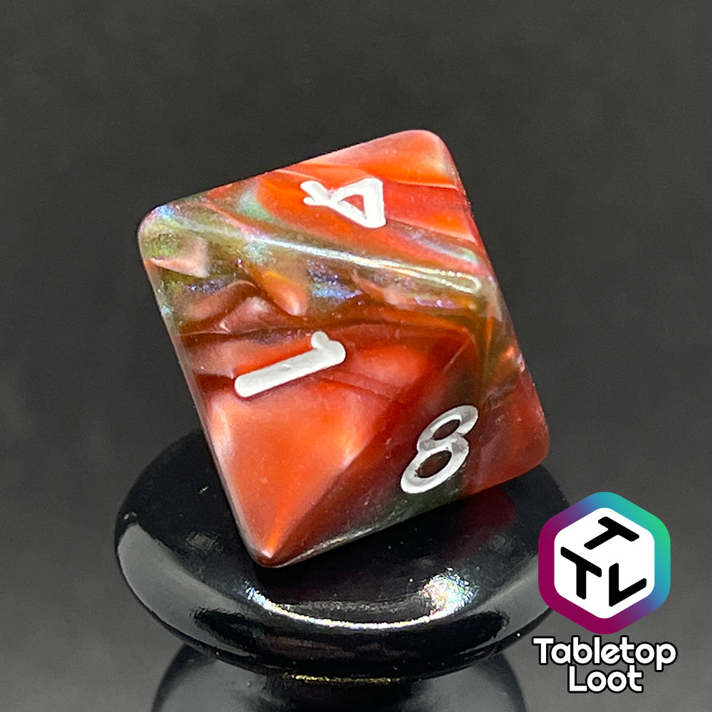 A close up of the D8 from the Ether Stone 7 piece dice set from Tabletop Loot with glittering and pearlescent swirls of red, green, blue, and golden brown with white numbering.