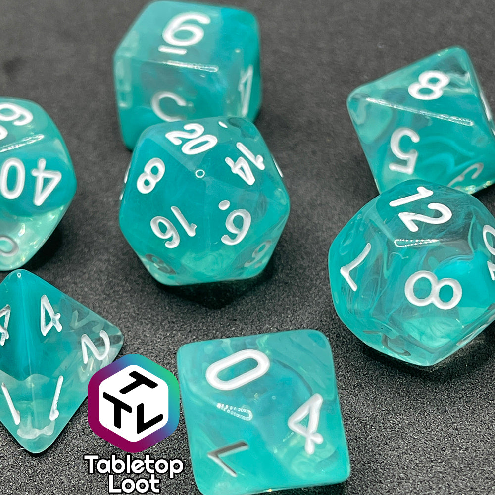 The Feather Fall 7 piece dice set from Tabletop Loot with swirls of teal in clear and white numbering.