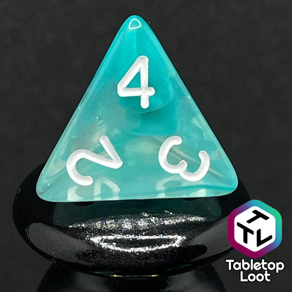 A close up of the D4 from the Feather Fall 7 piece dice set from Tabletop Loot with swirls of teal in clear and white numbering.