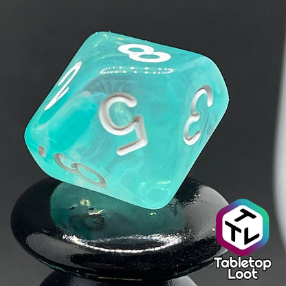 A close up of the D10 from the Feather Fall 7 piece dice set from Tabletop Loot with swirls of teal in clear and white numbering.