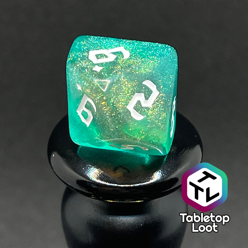 A close up of the D10 from the Fey Moss 7 piece dice set from Tabletop Loot with swirls of glittery green and yellow and white bold gothic numbering.