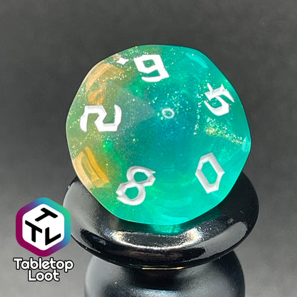 A close up of the D10 from the Fey Moss 7 piece dice set from Tabletop Loot with swirls of glittery green and yellow and white bold gothic numbering.