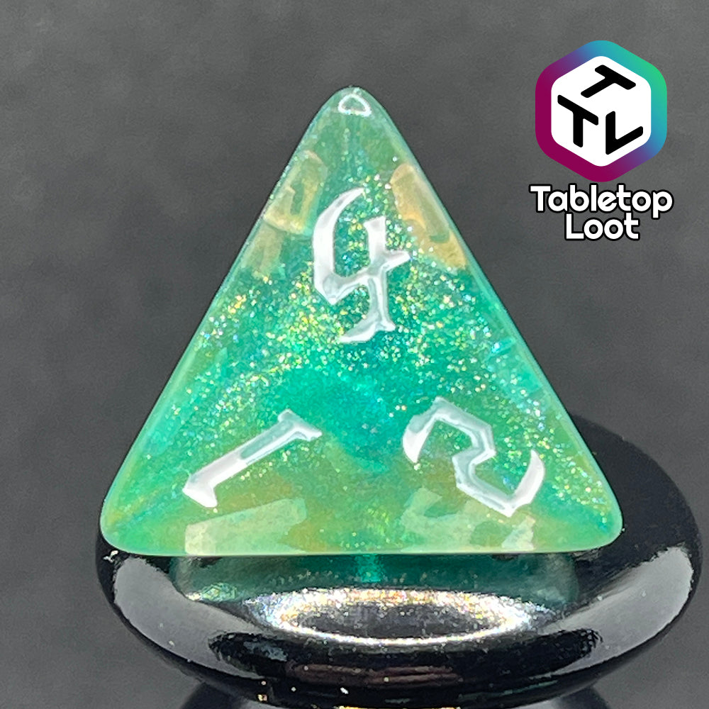 A close up of the D4 from the Fey Moss 7 piece dice set from Tabletop Loot with swirls of glittery green and yellow and white bold gothic numbering.