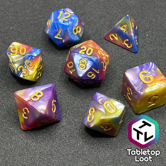 The Fey and Flowers 7 piece dice set with swirls of pearlescent shades of yellow, purple, red, blue, and green and gold numbering.