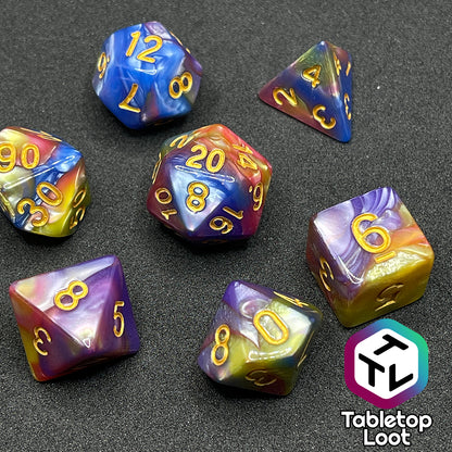 The Fey and Flowers 7 piece dice set with swirls of pearlescent shades of yellow, purple, red, blue, and green and gold numbering.