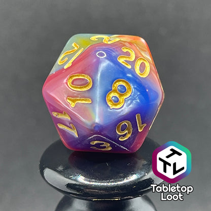 A close up of the D20 from the Fey and Flowers 7 piece dice set with swirls of pearlescent shades of yellow, purple, red, blue, and green and gold numbering.