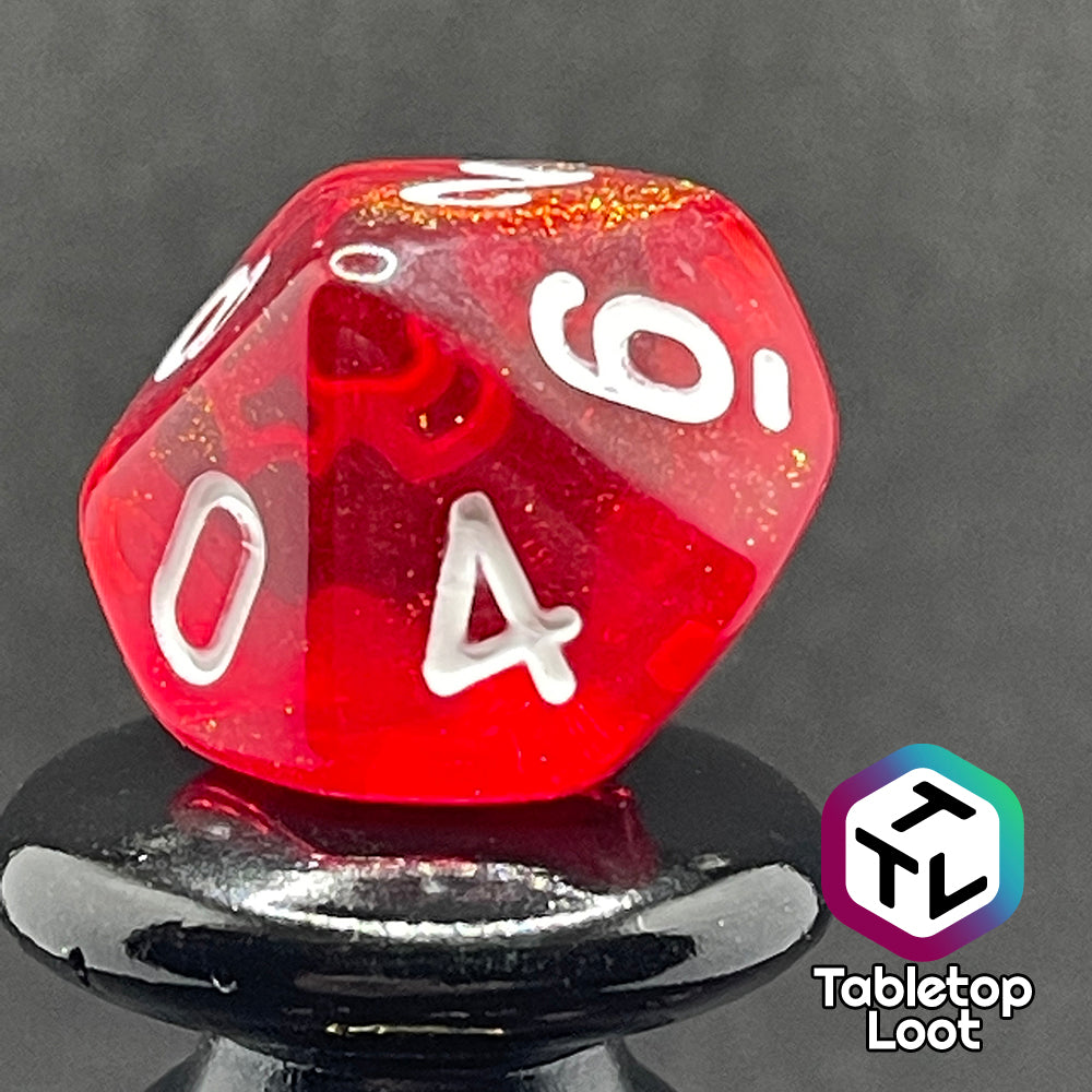 A close up of the D10 from the Fire Genasi 7 piece dice set from Tabletop Loot with swirls of gold micro glitter in red with white numbering.