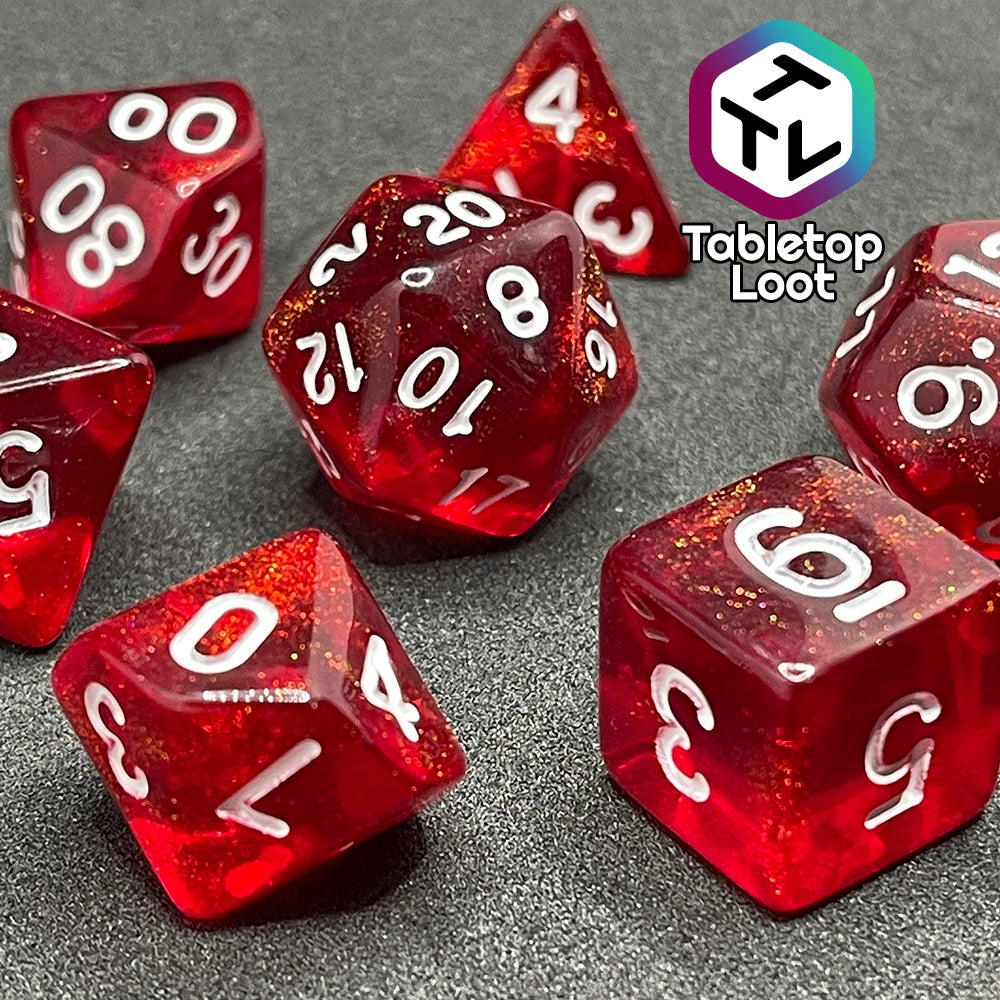 A close up of the Fire Genasi 7 piece dice set from Tabletop Loot with swirls of gold micro glitter in red with white numbering.