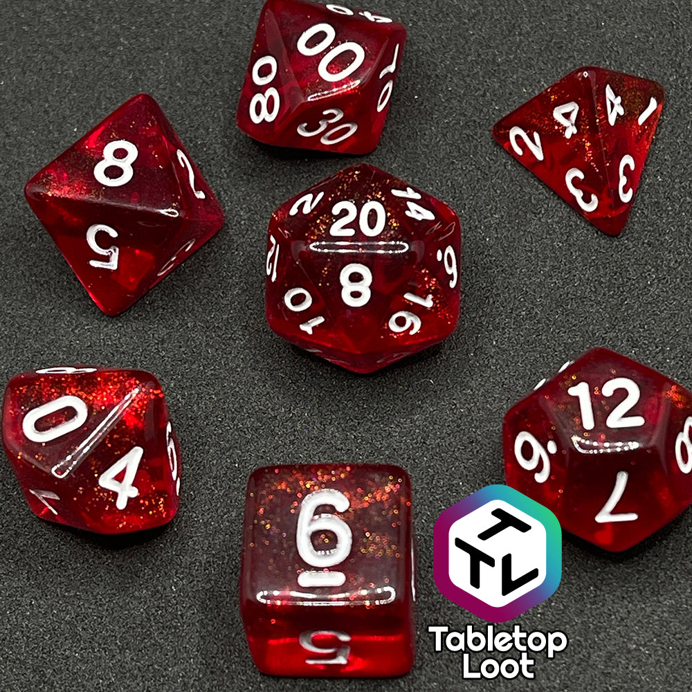 The Fire Genasi 7 piece dice set from Tabletop Loot with swirls of gold micro glitter in red with white numbering.
