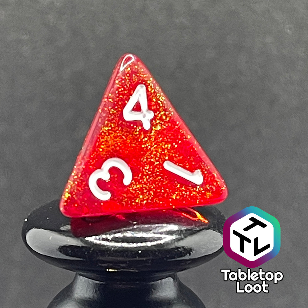 A close up of the D4 from the Fire Genasi 7 piece dice set from Tabletop Loot with swirls of gold micro glitter in red with white numbering.