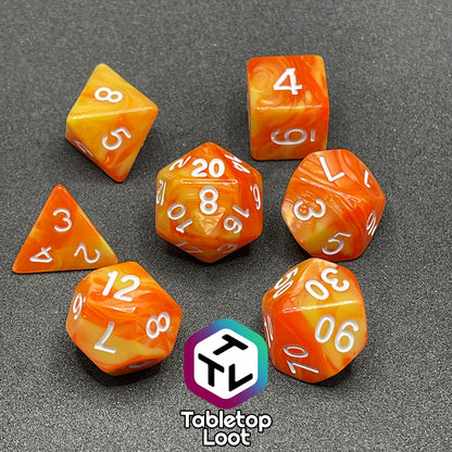 The Fireball 7 piece dice set from Tabletop Loot, swirling with yellow and orange and inked in white.