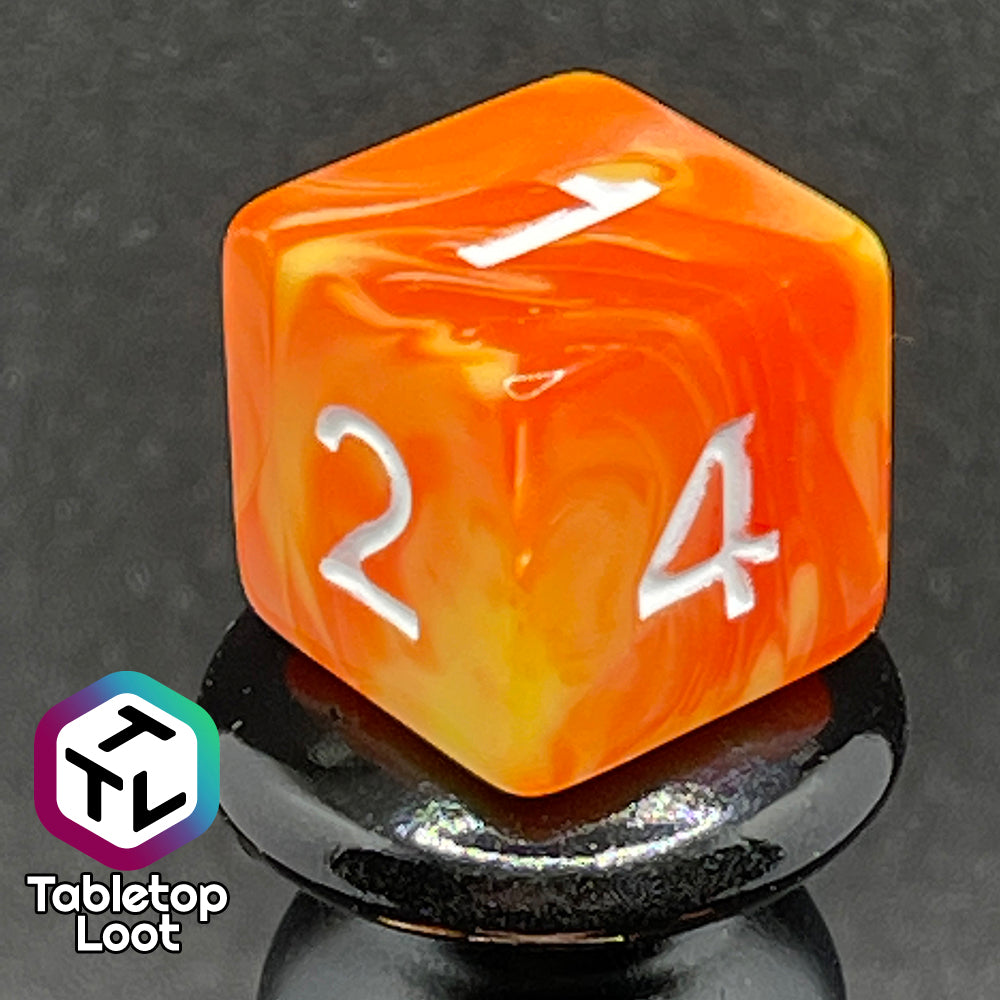 A close up of the D6 from the Fireball 7 piece dice set from Tabletop Loot, swirling with yellow and orange and inked in white.