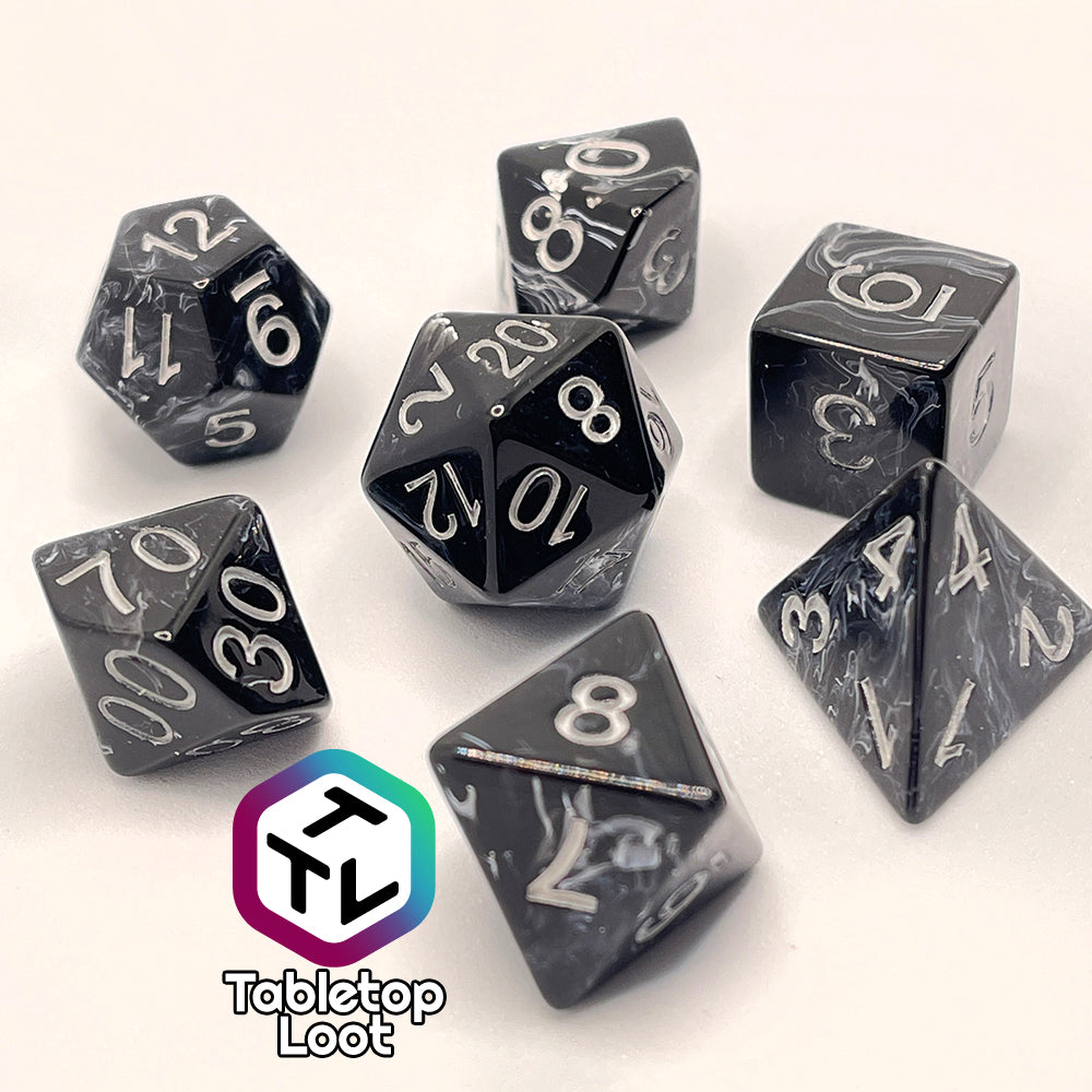 The Form of Dread 7 piece dice set from Tabletop Loot with swirls of white in black resin and silver numbering.