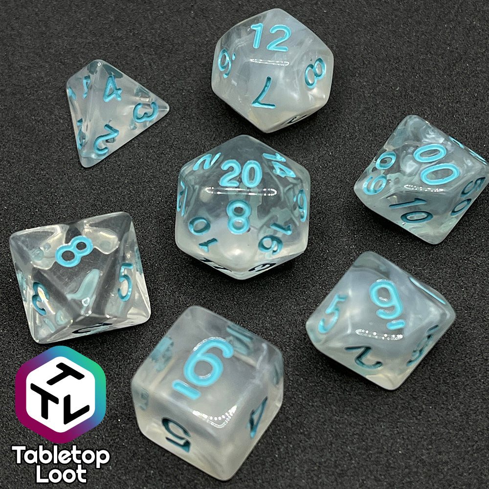 The Frostmaiden 7 piece dice set from Tabletop Loot with swirls of frosty white in clear resin and blue numbering.