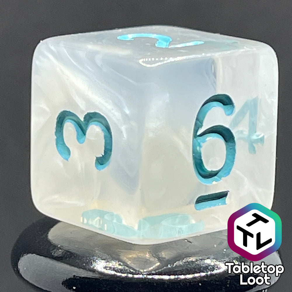 A close up of the D6 from the Frostmaiden 7 piece dice set from Tabletop Loot with swirls of frosty white in clear resin and blue numbering.