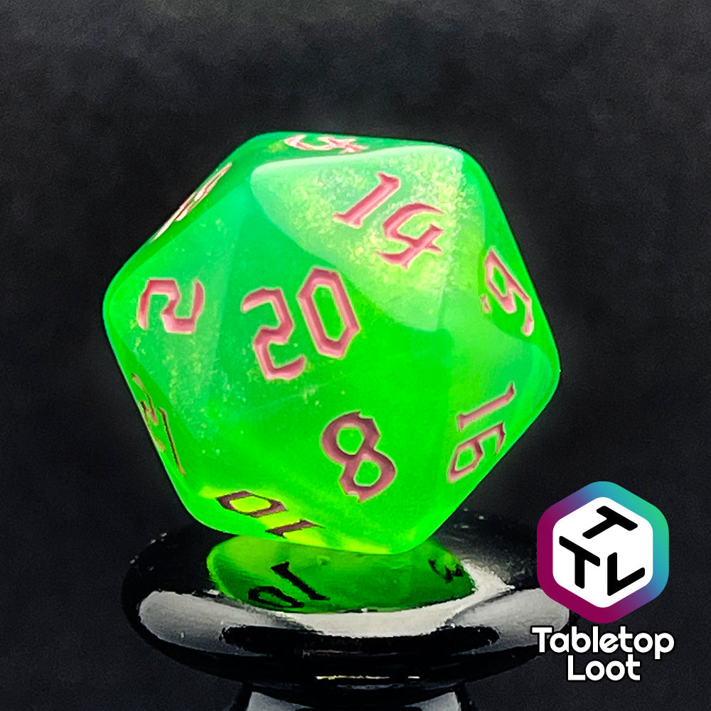 A close up of the D20 from the Sour Apple 7 piece dice set from Tabletop Loot; shimmery green dice with pink gothic numbering.
