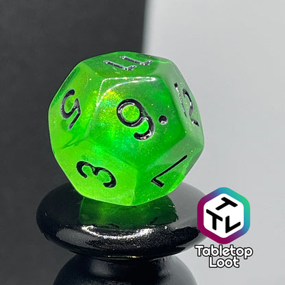 A close up of the D12 from the Gelatinous Cube 7 piece dice set from Tabletop Loot; lime green with gold shimmer and black numbering.