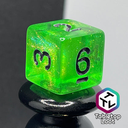 A close up of the D6 from the Gelatinous Cube 7 piece dice set from Tabletop Loot; lime green with gold shimmer and black numbering.
