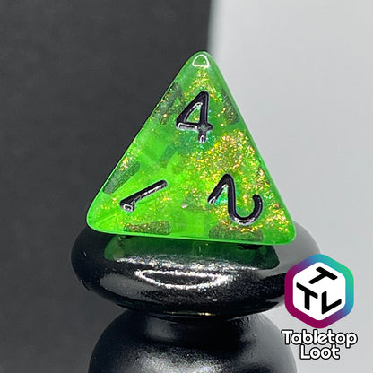 A close up of the D4 from the Gelatinous Cube 7 piece dice set from Tabletop Loot; lime green with gold shimmer and black numbering.