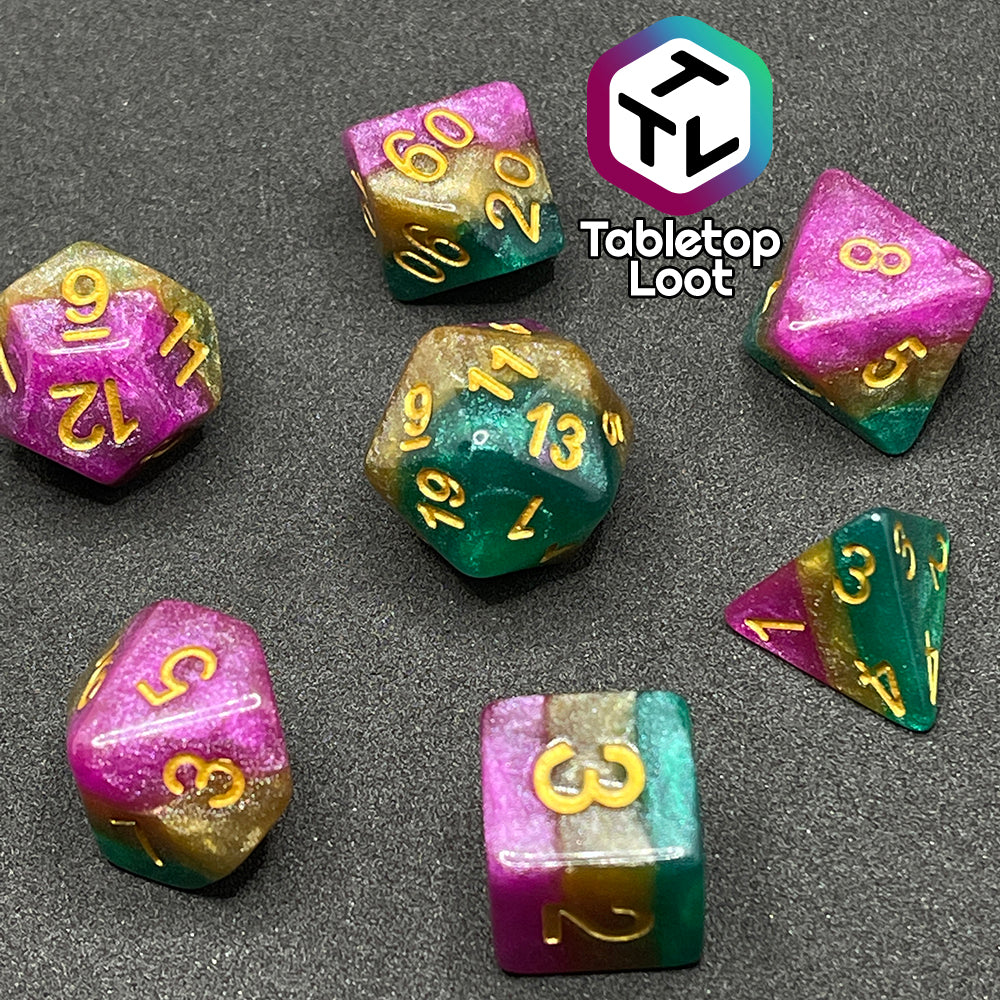 The Gem of Brightness 7 piece dice set from Tabletop Loot with stripes of glittery pink, gold, and green and inked in gold.