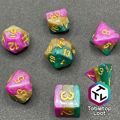 The Gem of Brightness 7 piece dice set from Tabletop Loot with stripes of glittery pink, gold, and green and inked in gold.