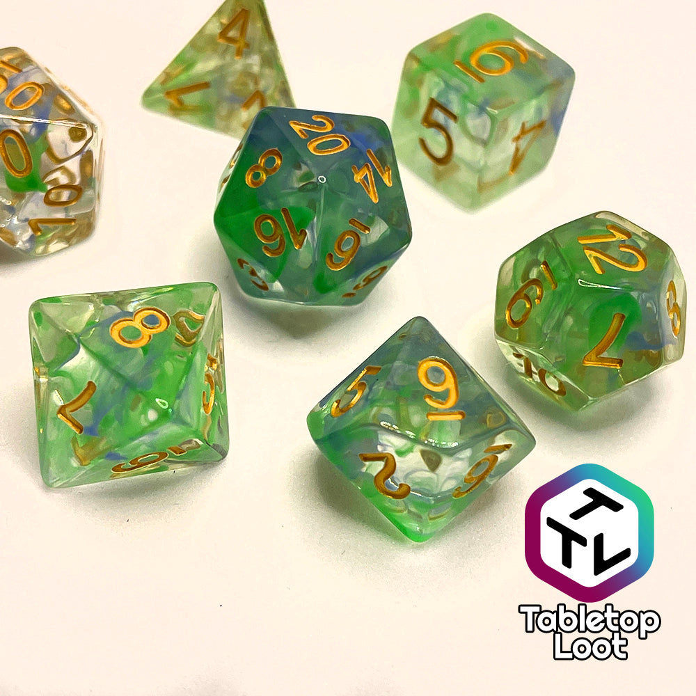 The Gentle Repose 7 piece dice set with swirls of bright green and blue in clear resin and gold numbering.