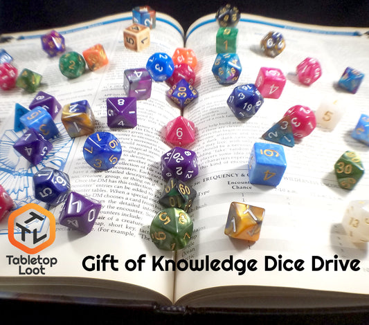 Dice are scattered all over an open Dungeons and Dragons book with the Tabletop Loot logo and "Gift of Knowledge Dice Drive" written on it.
