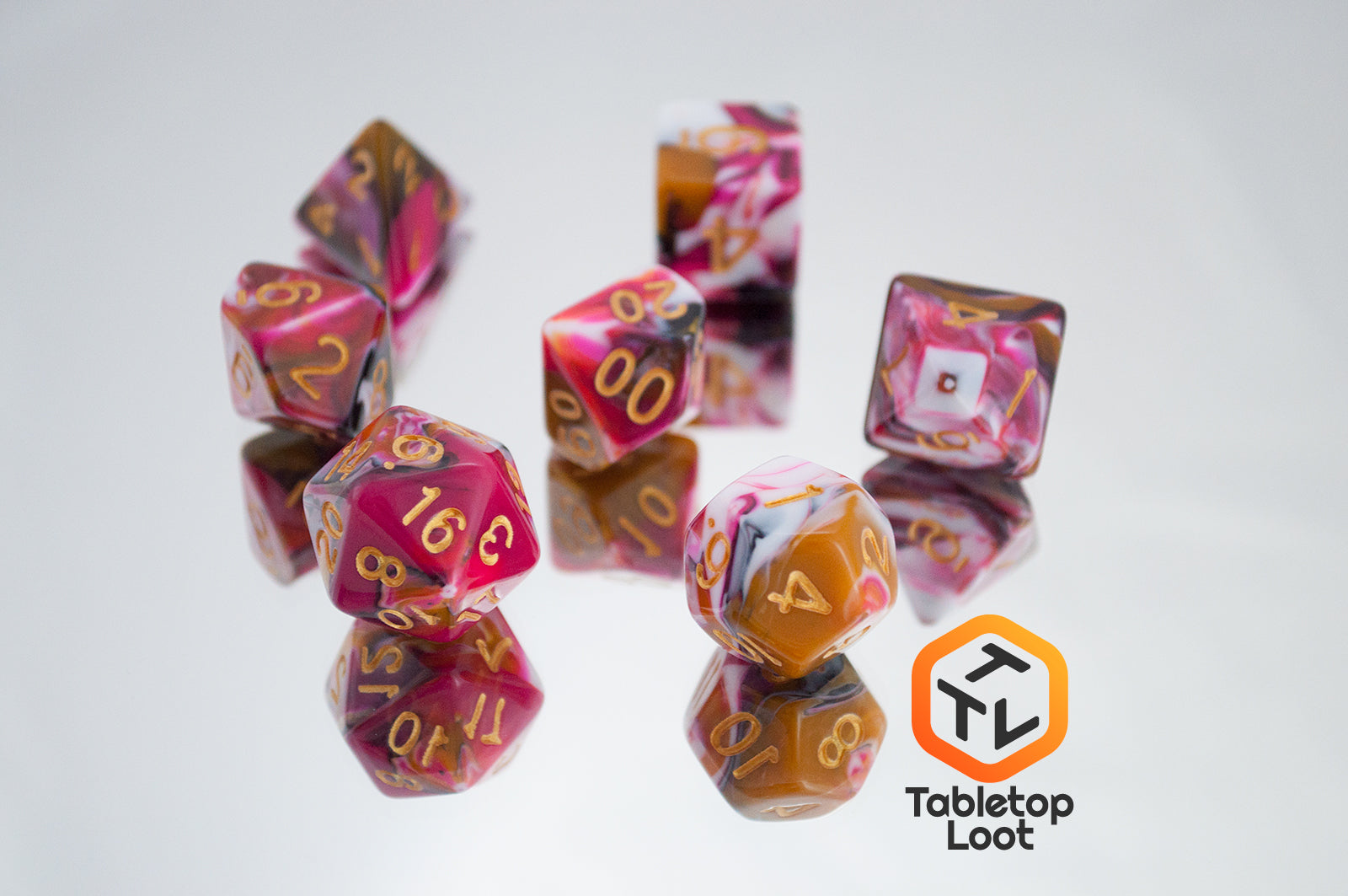 The GoodBerries 7 piece dice set from Tabletop Loot with swirls of red, brown, black, and white and gold numbering.